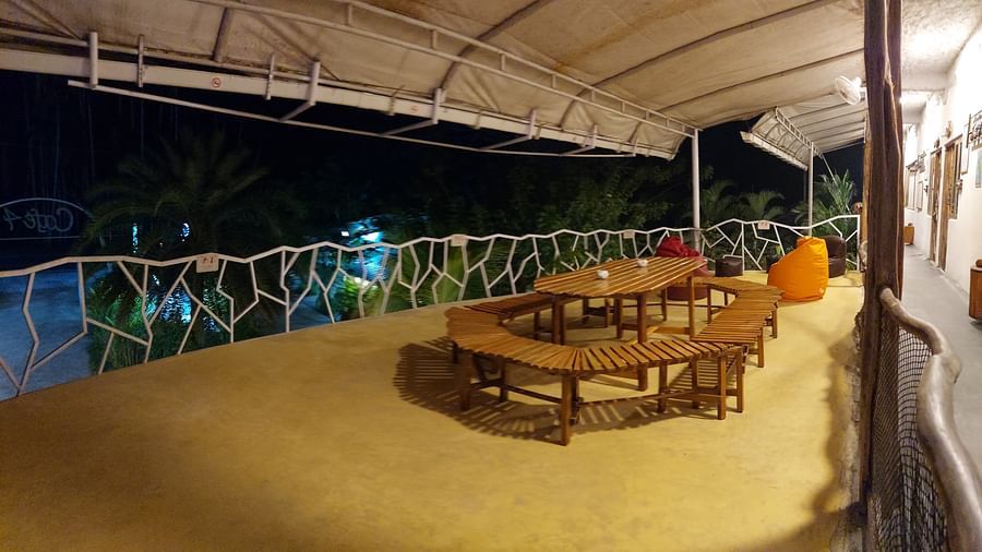 Night view of a dining area with a long table and chairs under a covered structure -  Matsya Island Retreat by Island Quest.