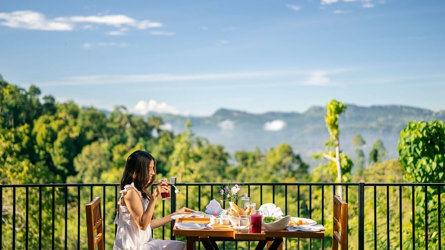 Woman having breakfast with a scenic mountain view