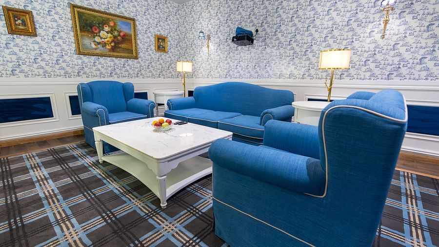 Two chairs and a sofa placed around a coffee table in the living room - The Manor Luxury Hotel, Shimla