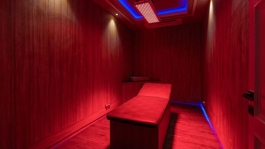 alt-text A landscape image of the spa room with red lighting and a bed  - The Manor Luxury Hotel, Shimla