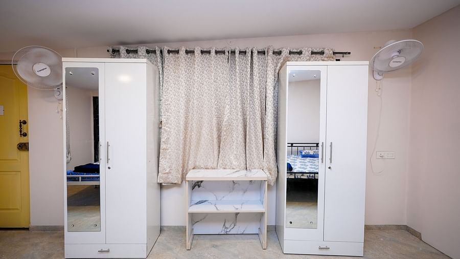 Clean and organized hostel room with curtained beds and mirror doors | Diamond Parks, Pune 