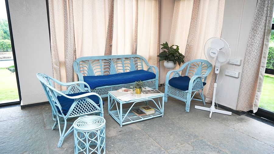 Bright and airy hostel common area with blue furniture and large windows | Diamond Parks, Pune 