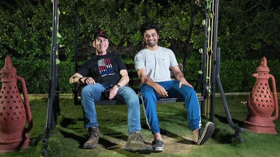 Two men relaxing on a swing in a night-time garden setting | Diamond Parks, Pune