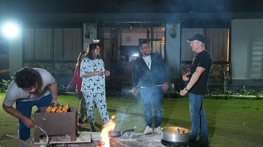 Group of people cooking and socializing outdoors at a hostel barbecue night | Diamond Parks, Pune 