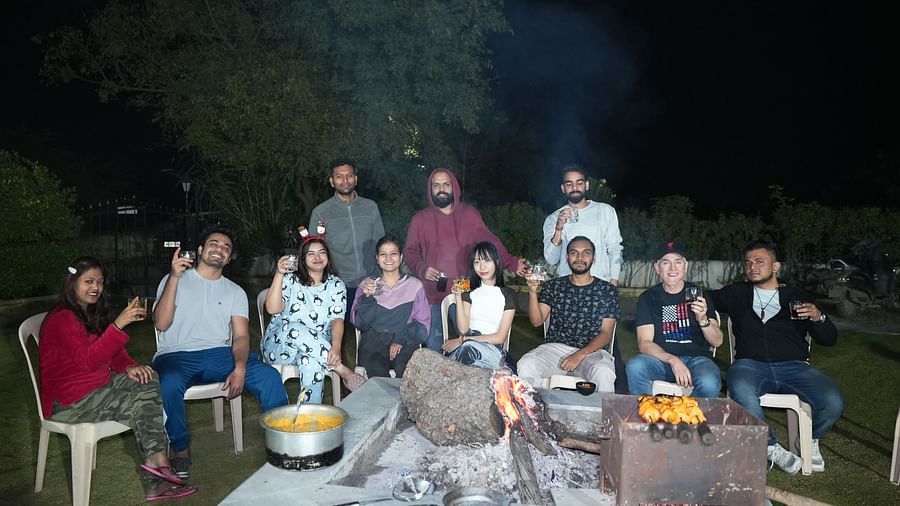 Outdoor night scene of a hostel gathering with guests enjoying a barbecue | Diamond Parks, Pune 