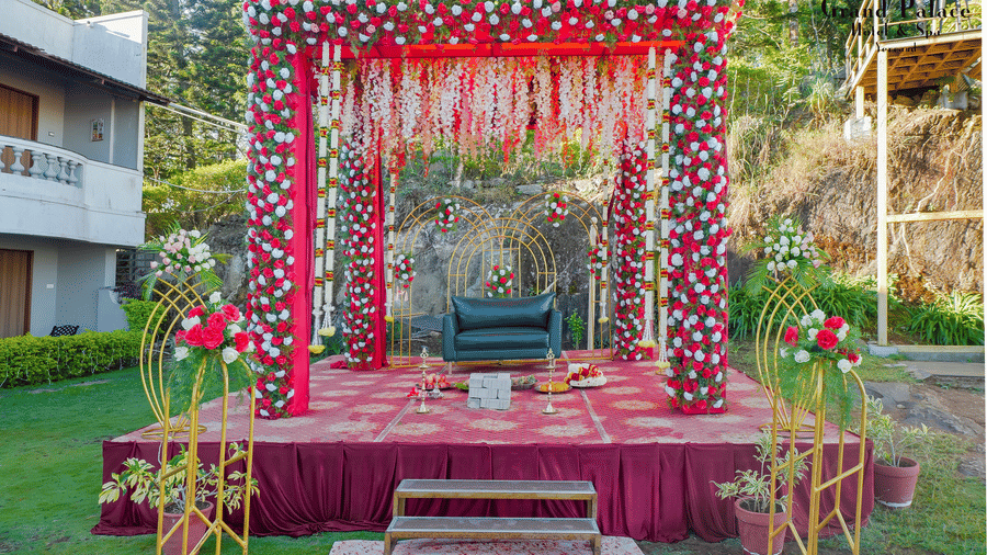 Outdoor wedding stage at Grand Palace, Yercaud with floral backdrop, chairs, steps, walkway, floral decorations, and garden area ready for ceremony.