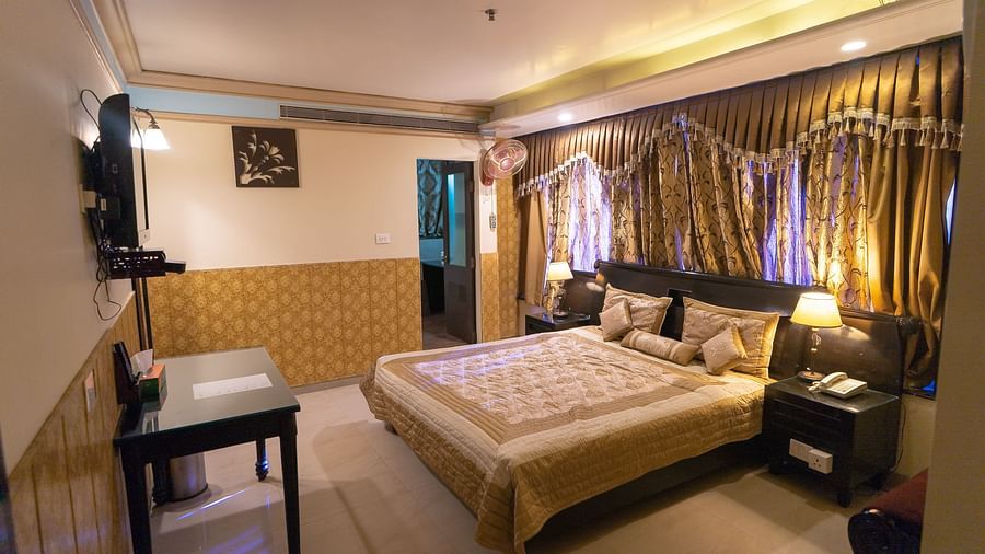Queen Room featuring a bed, a desk, and a television. - Hotel Ashok Nagpur