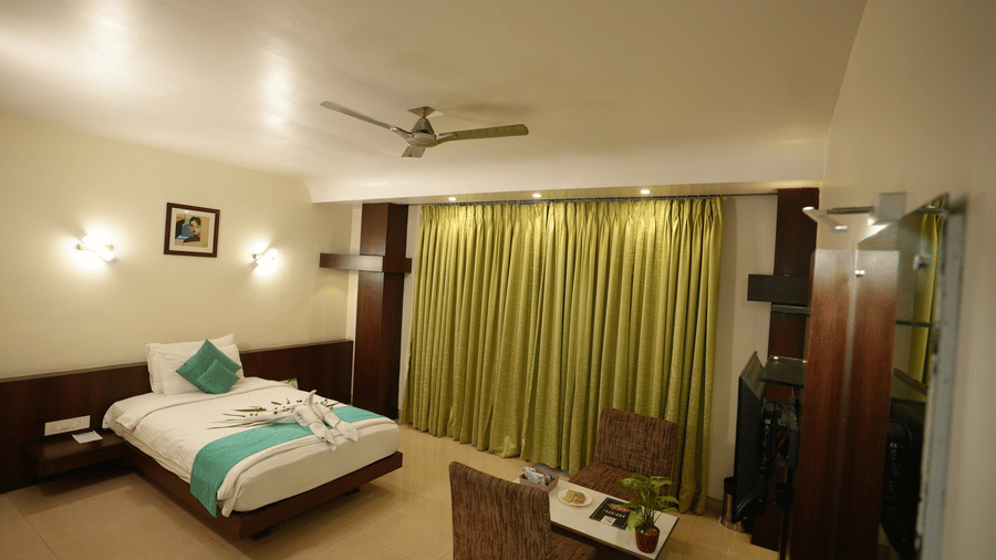 Spacious room with warm lighting, curtains, and a comfortable double bed at Pipul Utkal Continental, Jharsuguda.