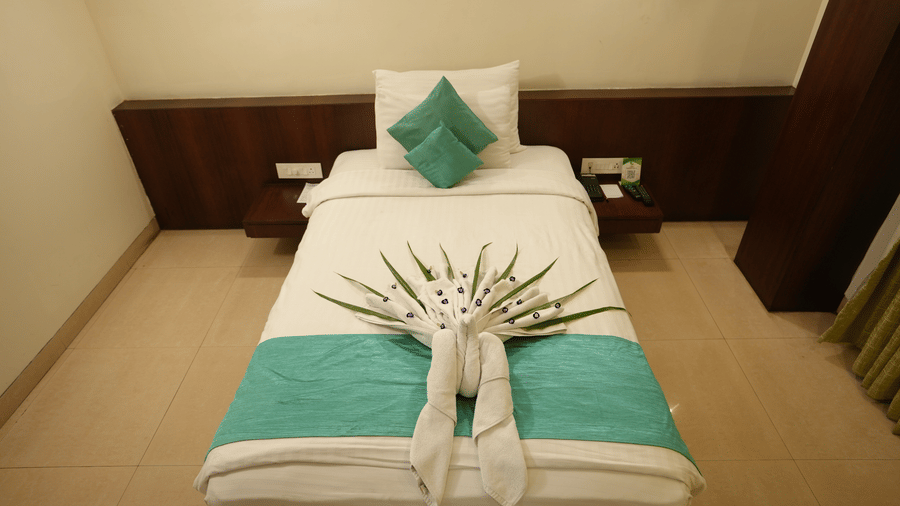 Comfortable hotel room with neatly made bed and soft lighting at Pipul Utkal Continental, Jharsuguda.