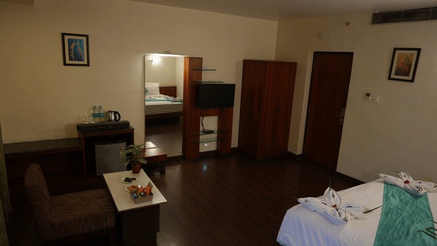 Suite with seating area, modern furnishings, and a neatly made bed at Pipul Utkal Continental, Jharsuguda.