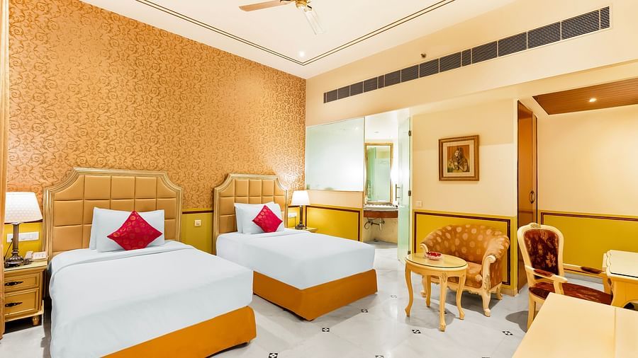 An overview of a room with two single beds, lamps and side tables - Rajasthali Resort & Spa, Jaipur.