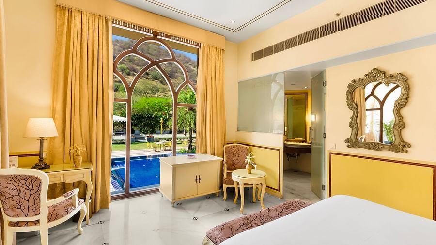 An overview of a room with a double bed and floor to ceiling window in view - Rajasthali Resort & Spa, Jaipur.