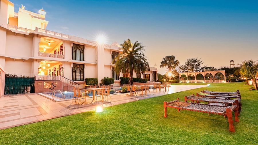 Lawn area with a sit out in front of the building in the night - Rajasthali Resort & Spa, Jaipur.