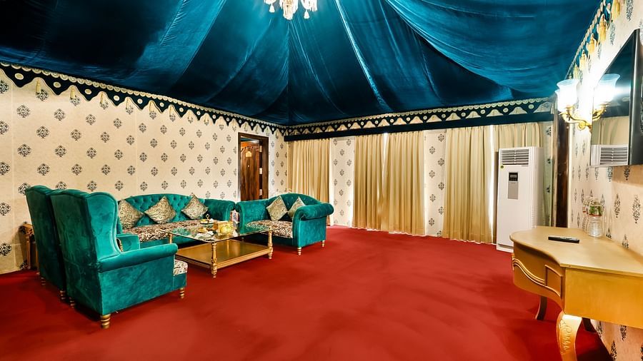 An overview of the living room with sofas, coffee table and a chandelier - Rajasthali Resort & Spa, Jaipur.