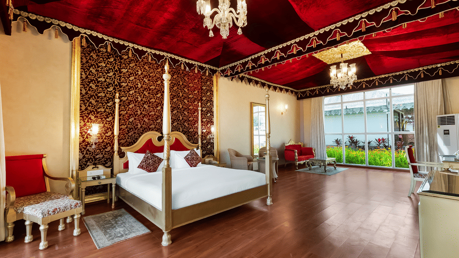 Grand Luxury Villa With Private Pool with a plush bed, side tables and lamps under a chandelier at Rajasthali Resort & Spa, Jaipur