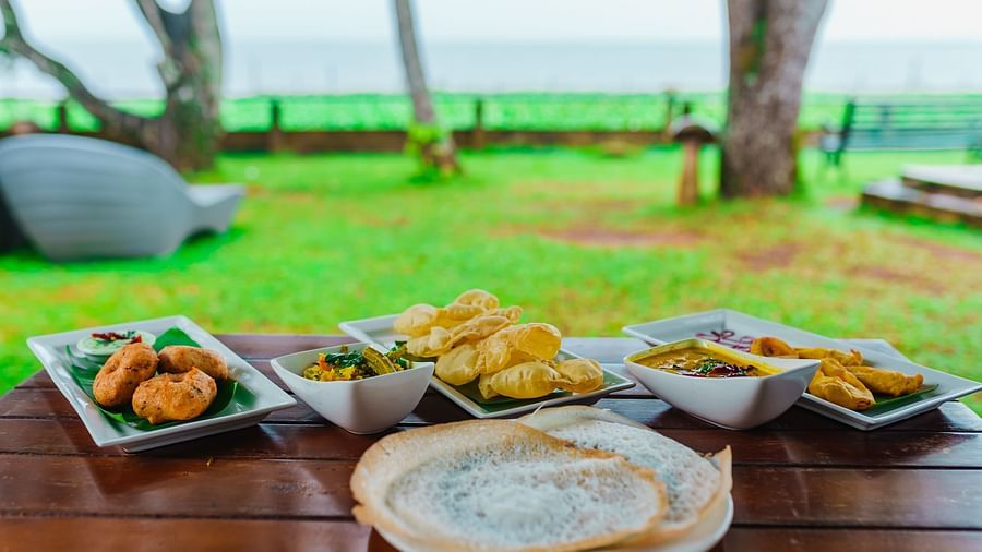 Rhythm Kumarakom - Breakfast on table with the garden in the background
