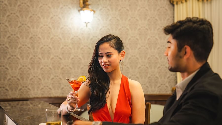 Couple sharing cocktails in a cozy and stylish setting at The Claridges Nabha Residence