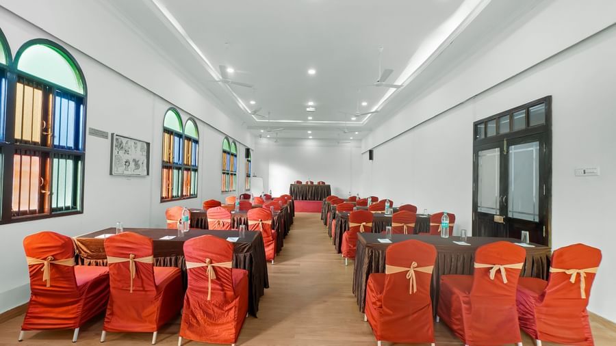 View from the back of the banquet hall with chairs neatly arranged with ribbons at WOW Bungalow, Yercaud.