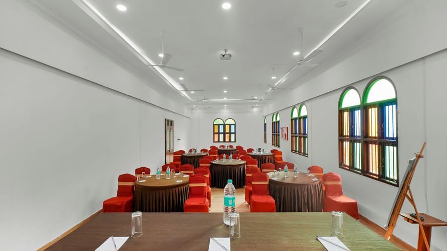 View from the front of the banquet hall with chairs arranged around the round table at WOW Bungalow, Yercaud.