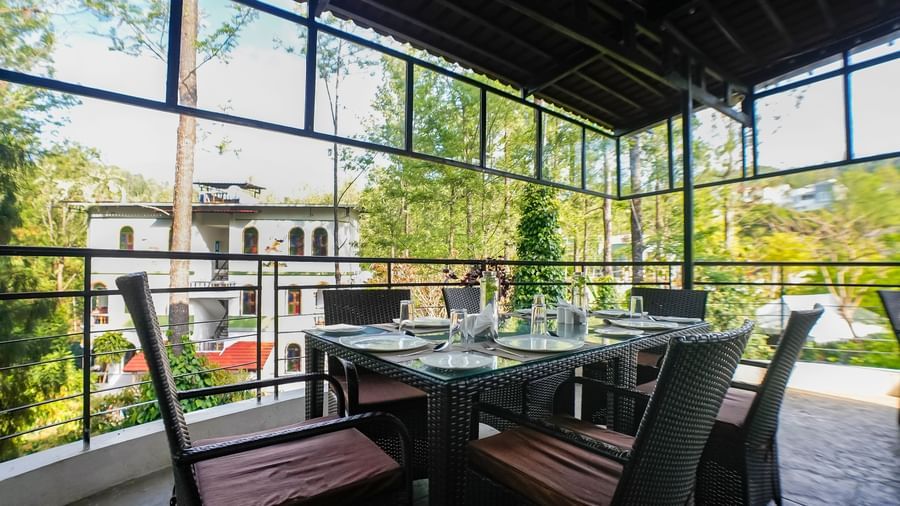 Close-up view of dining area with chairs arranged around the table at WOW Bungalow, Yercaud.