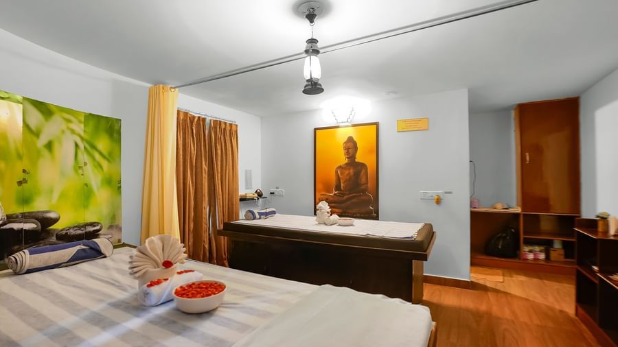 Spa room with two massage beds and a decorative wall mural at WOW Bungalow, Yercaud. 