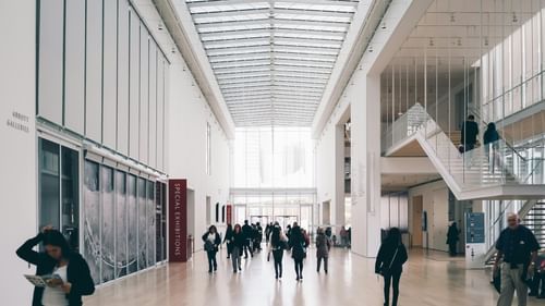 Image of an expansive exhibition hall with people walking all around.
