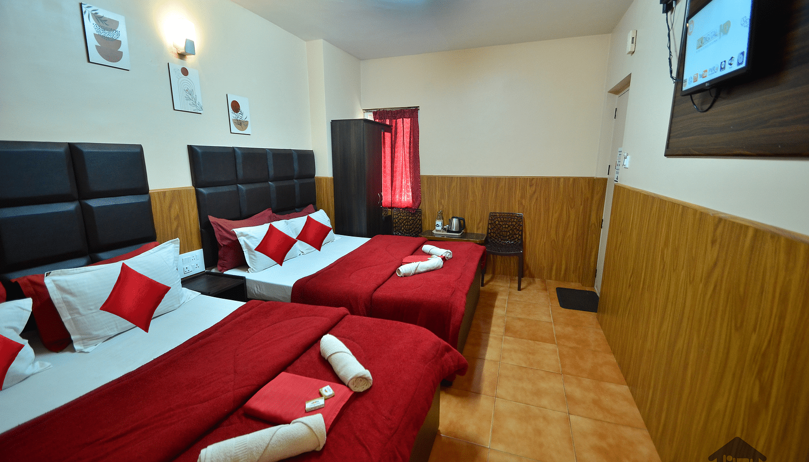 Image of two double beds and a television in front at BN Tourist Home.