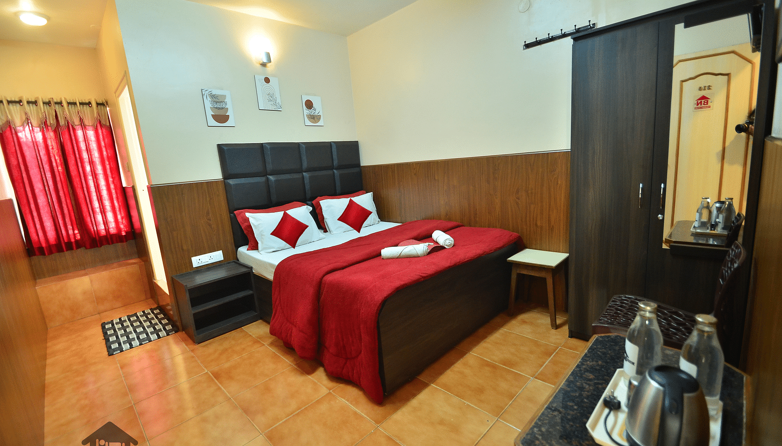 Image of a room with a bed, wardrobe, electric kettle and water bottle at BN Tourist Home, Ooty