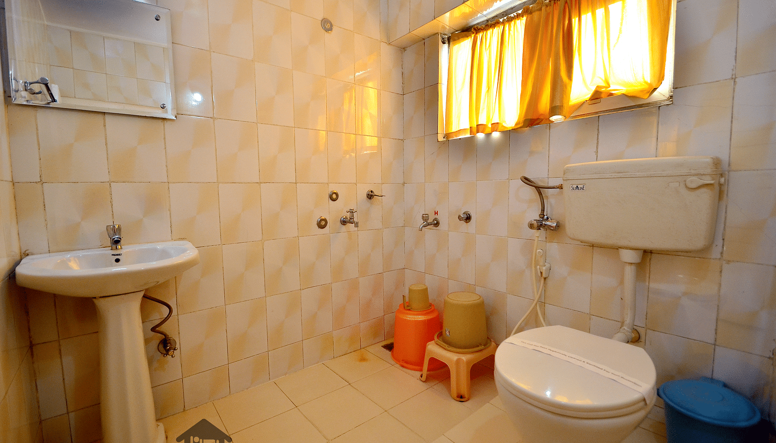 Image of a washroom with sink and a toilet at BN Tourist Home, Ooty.