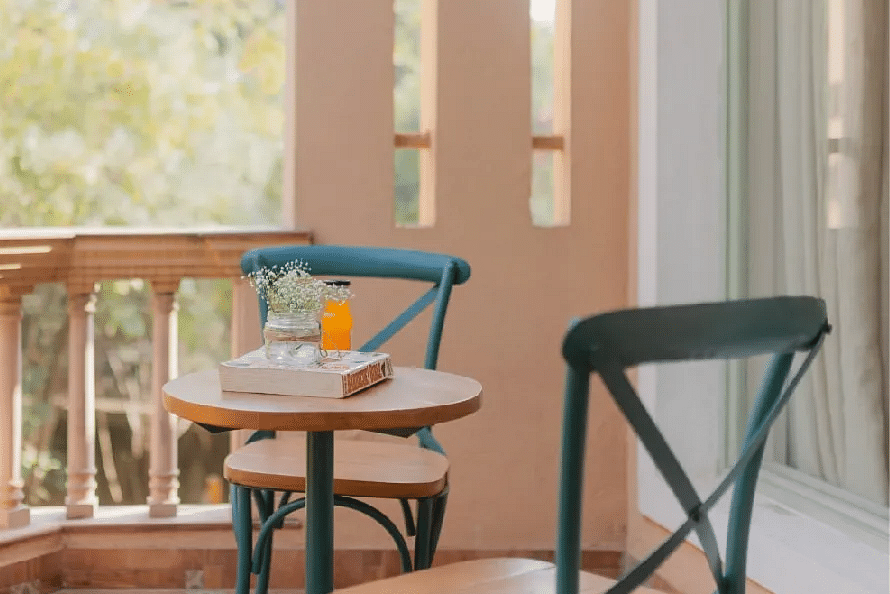 Two chairs and a small round table on a balcony at Karma Chalets.