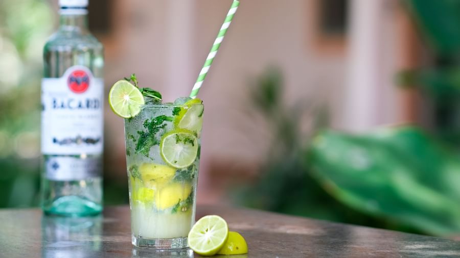 A glass of Mojito with a bottle of bacardi behind it | Mango Hill, Pondicherry