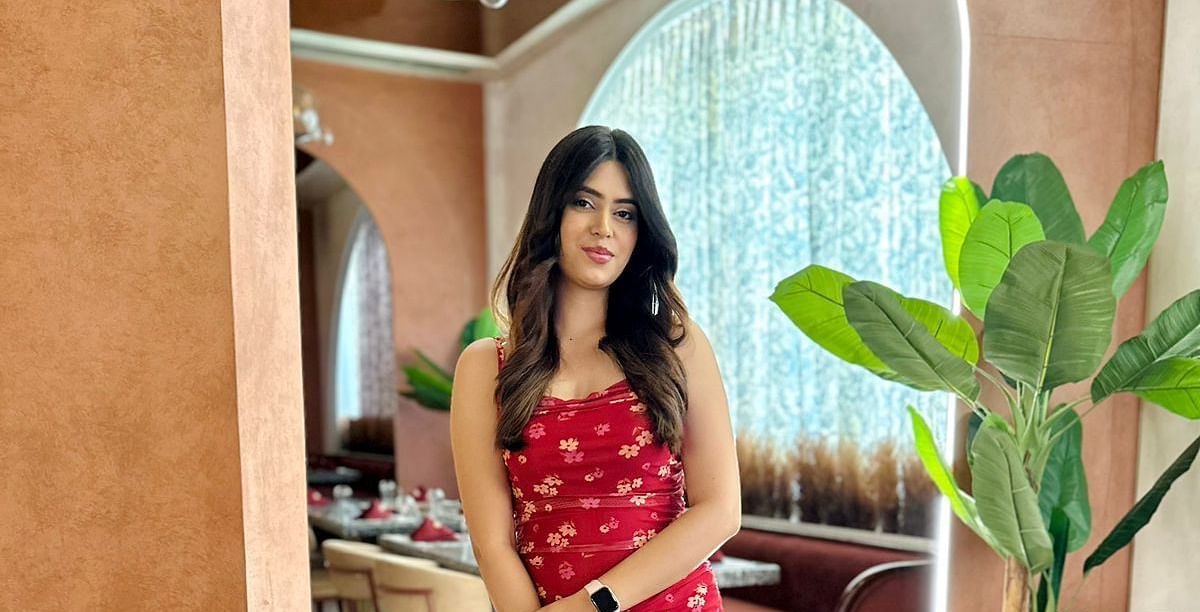 A woman posing for a photo in the warm ambiance of Themis Barbeque restaurant.