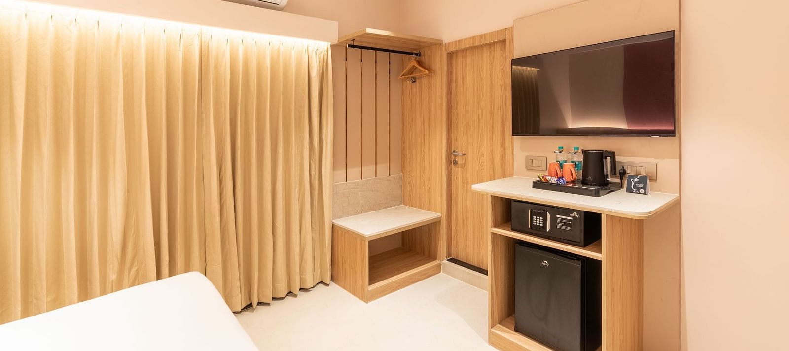  Kitchenette with a fridge and wardrobe in The Executive Rooms at TGI Livancia The Sojourn, Bangalore.
