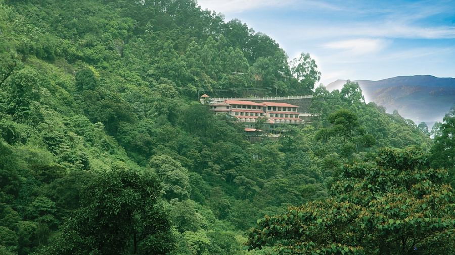 Abad Copper Castle Resort building partially hidden among dense, green foliage on a steep hillside.