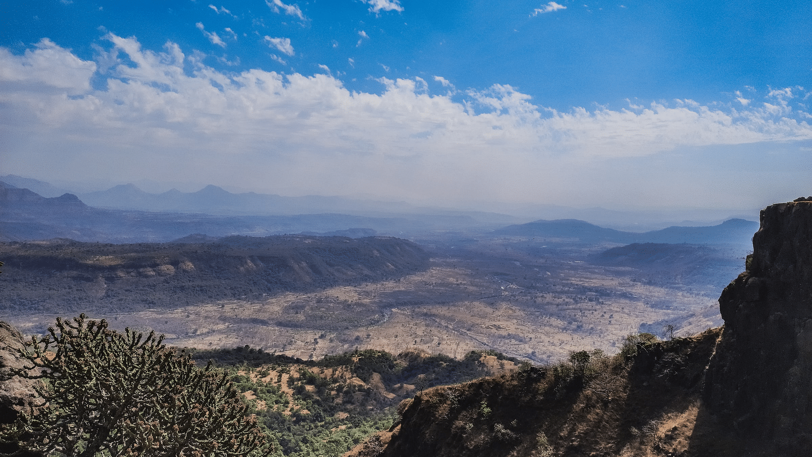 a panoramic view of valleys and clear skies during day time