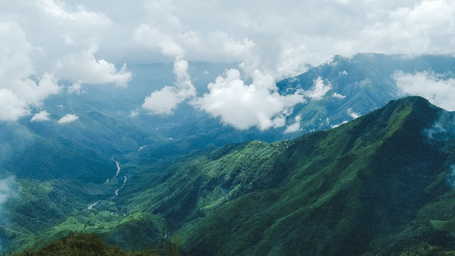 View of the green hills with clouds floating.