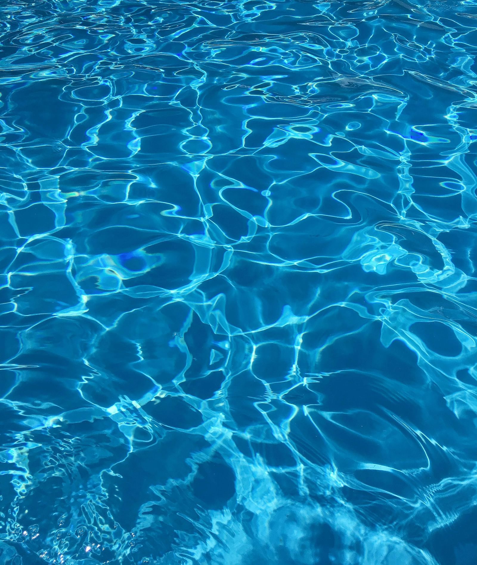 Reflections of light on the water in a swimming pool.