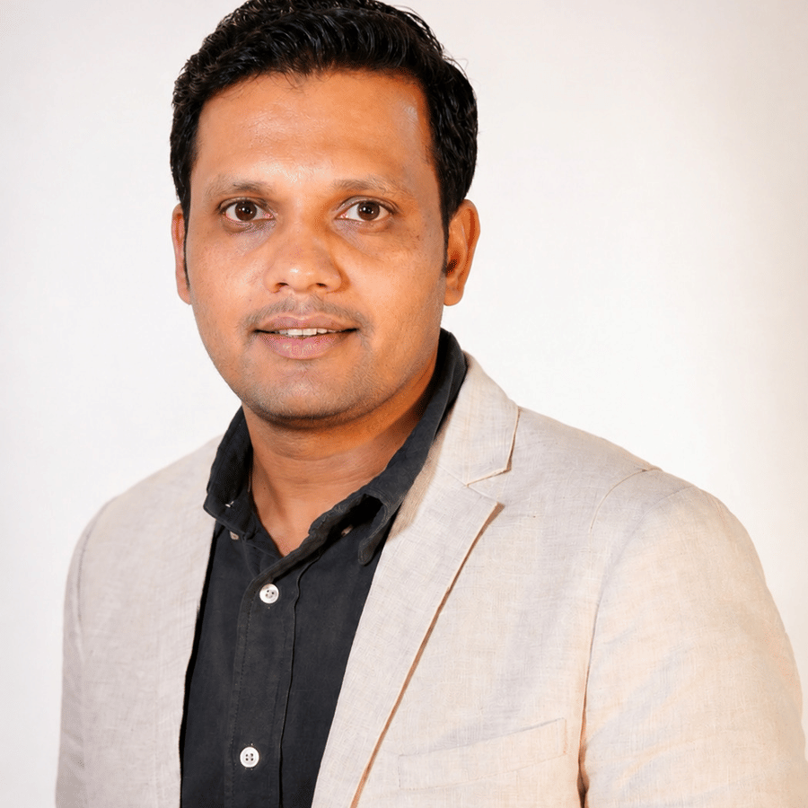 Portrait of Sandeep Soni, Corporate Manager Engineering at Pride Hotel Group, in a beige blazer against a plain white background.
