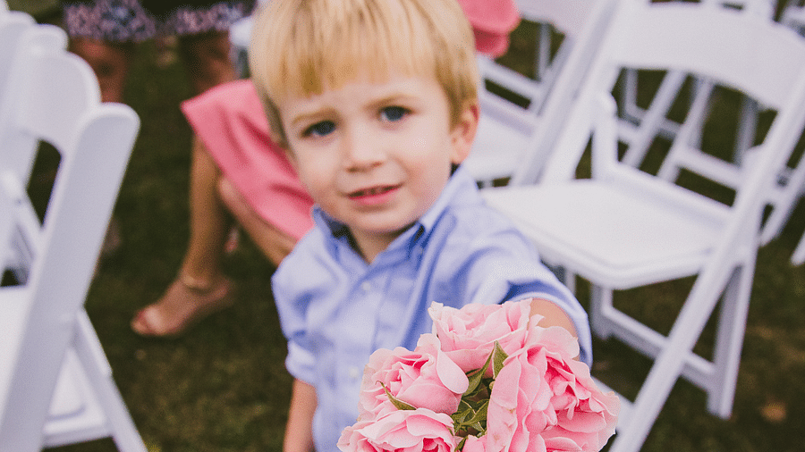 a cute toddler with blonde hair holding a bunch of pink roses - Historic Tapoco Lodge