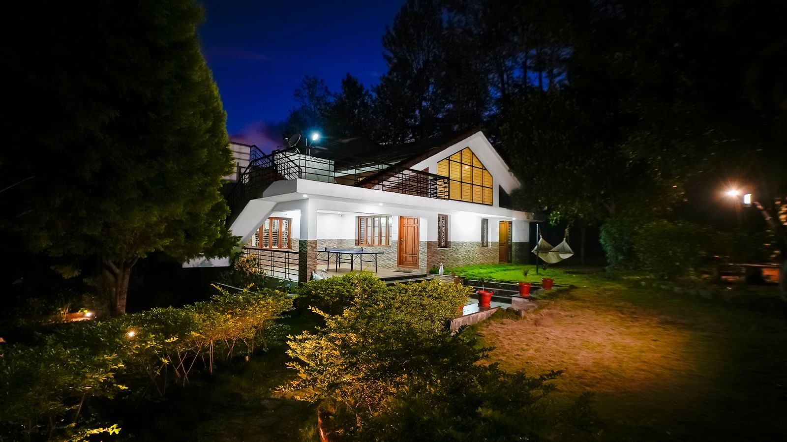 Facade view of WOW Bungalow, Yercaud, at night with a garden area.