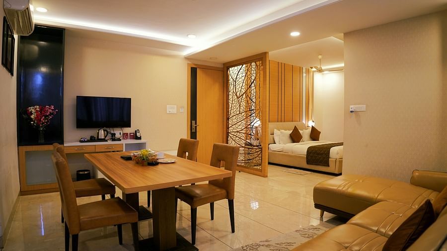 A modern living space featuring a dining area and a view into the bedroom - TGI Insignia, Bhopal