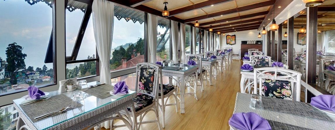 image of a dining space with a slanted roof and lights hanging from the ceiling at Yashshree Mall Road, Darjeeling.