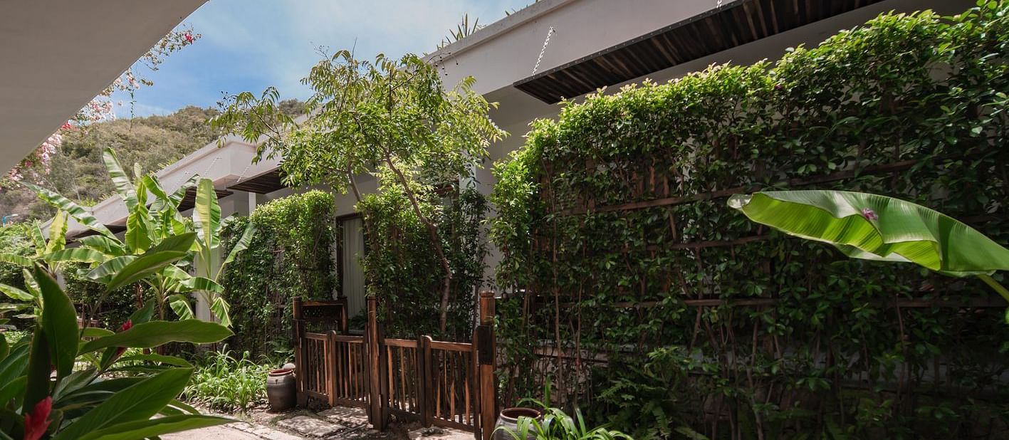 A outside view of a hotel room surrounded by lush green trees - Alibu Resort Nha Trang