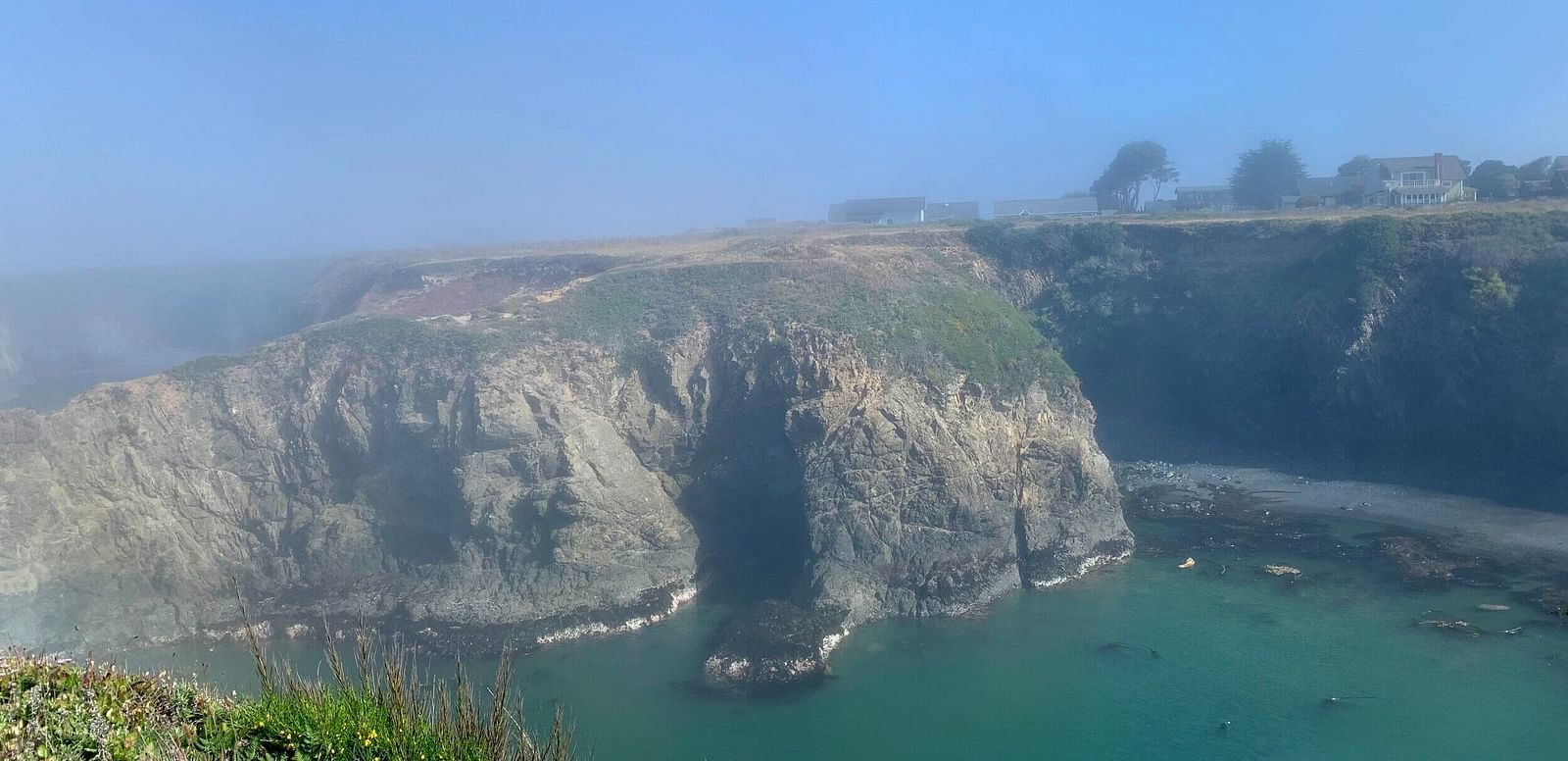 Hilly mountain cliff with water below