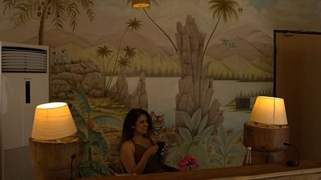 A woman sitting in a room which is well decorated and brightly lit - Utsav Camp Sariska