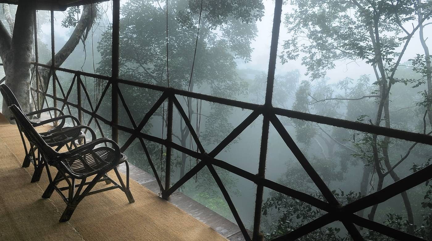 Two chairs in a balcony with forest views | Vythiri Resort. Wayanad