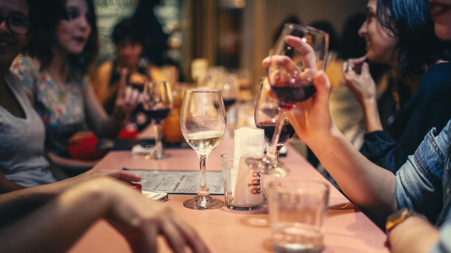 A group of people at a table raising their glasses in a toast, enjoying a social gathering.