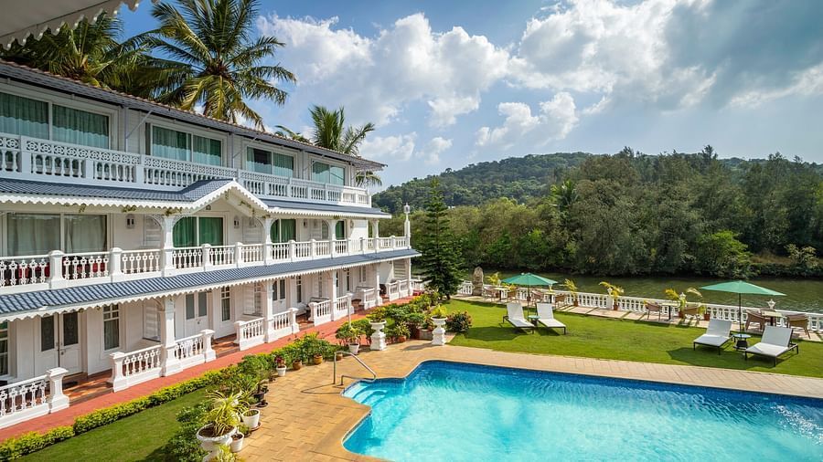 The facade of the hotel alongside the pool - Stone Wood Riverfront Resort, Siolim