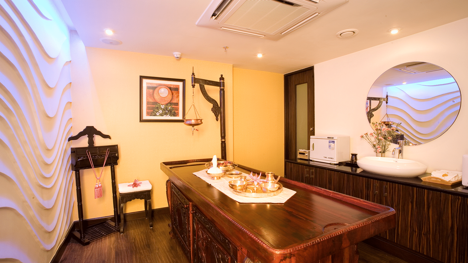 Spa table in front of textured wall side view at Grand Chennai By GRT Hotels.
