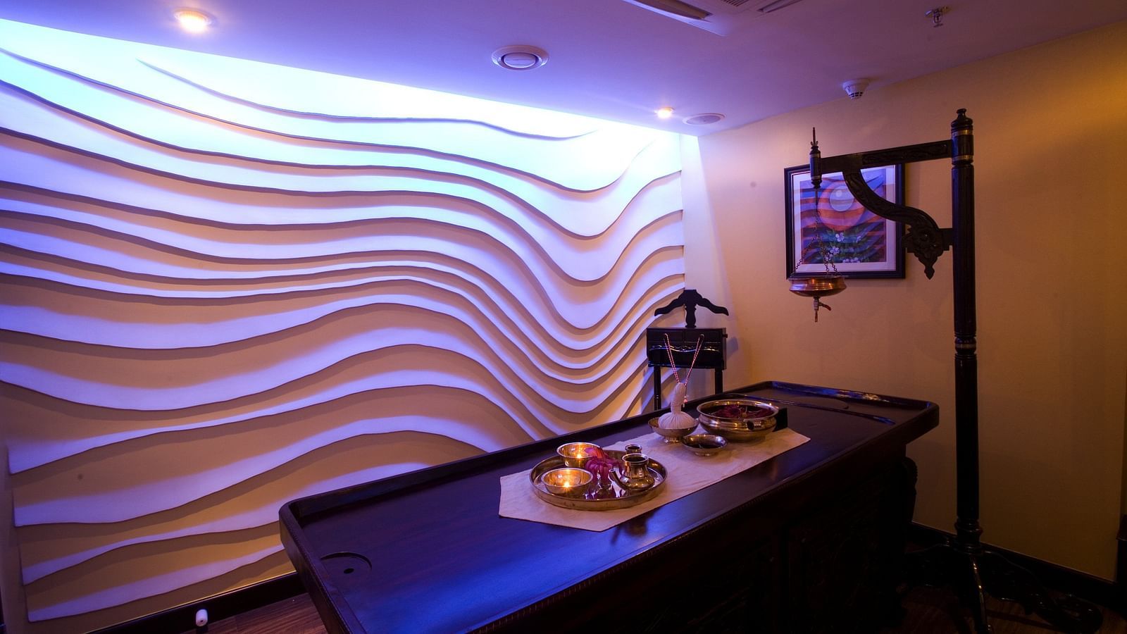 Spa table in front of textured wall side view at Grand Chennai By GRT Hotels.